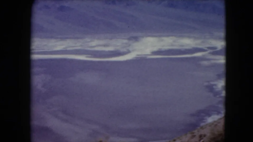 1961 Nevada 8mm aerial frame showing a broad pale channel or basin across purple desert terrain.