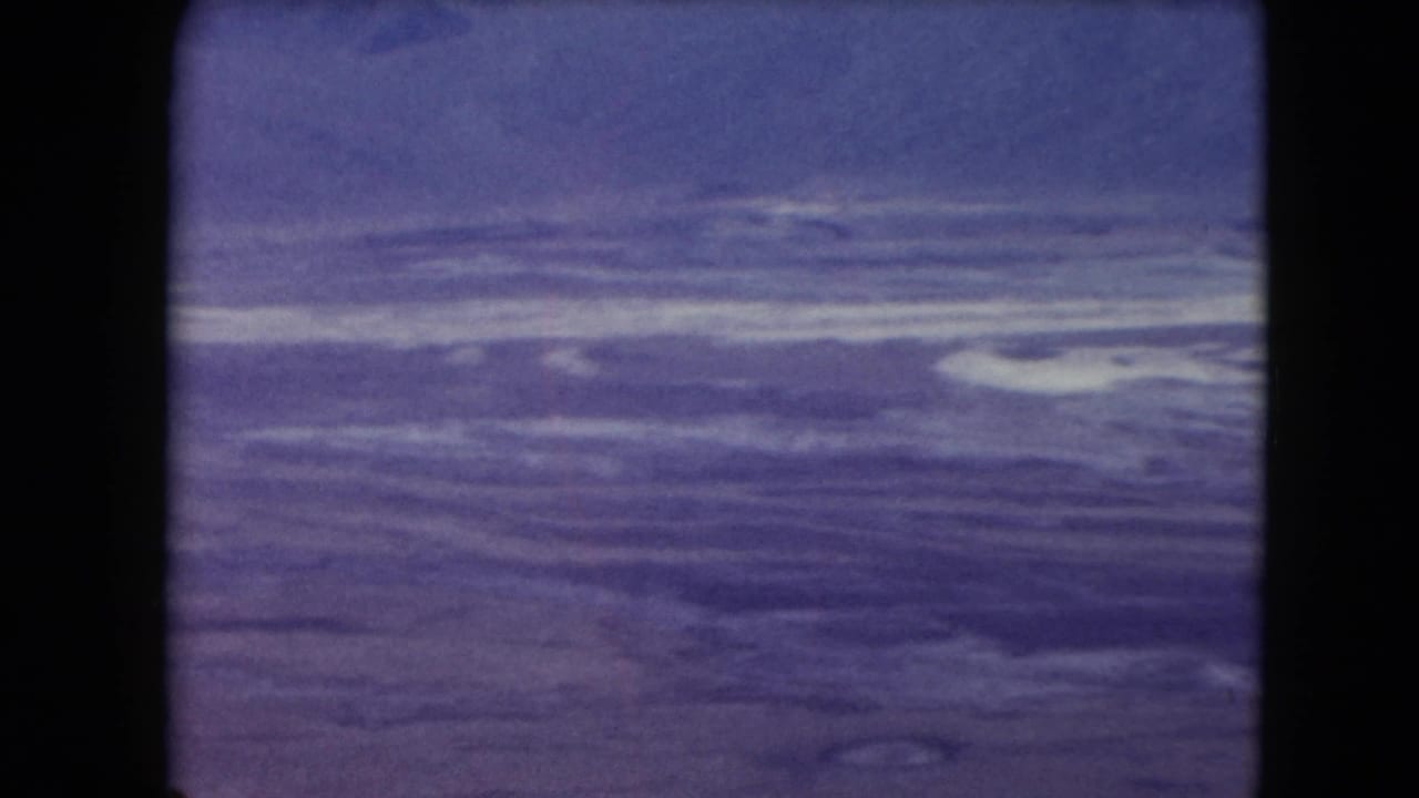 1961 Nevada 8mm frame showing a broad desert mountain view beneath a pale sky, with strong film borders visible.