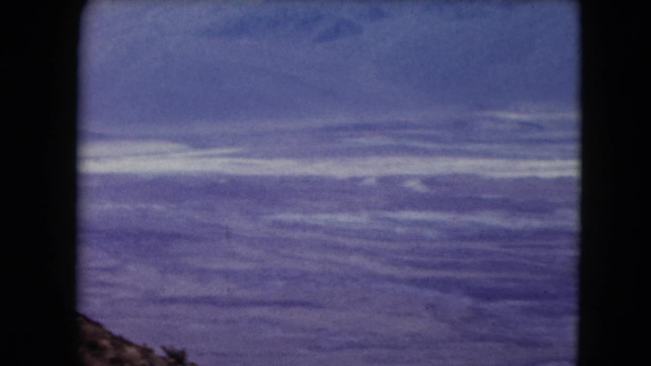 Desert ridges and sky with a small rocky hillside edge at lower center.