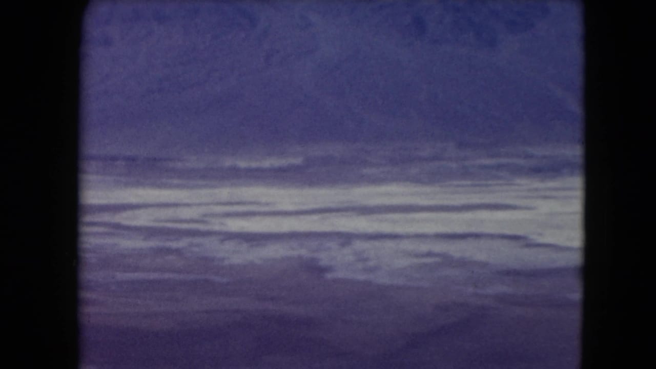 Flat pale desert or salt-like surface beneath a dark blue-purple sky.