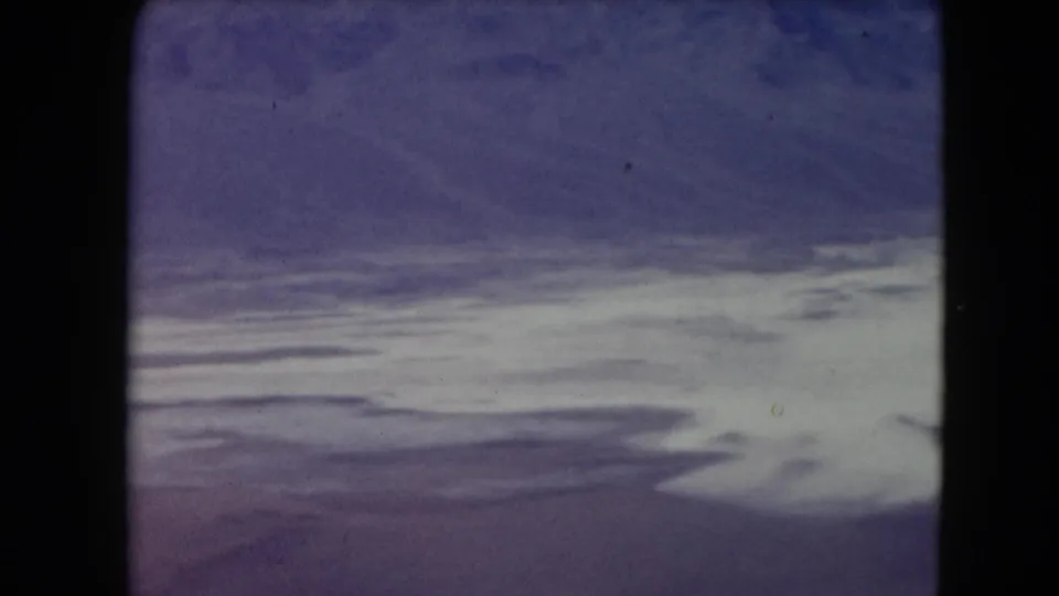 1961 Nevada 8mm landscape showing desert mountains above a broad pale winding watercourse or salt-flat pattern.