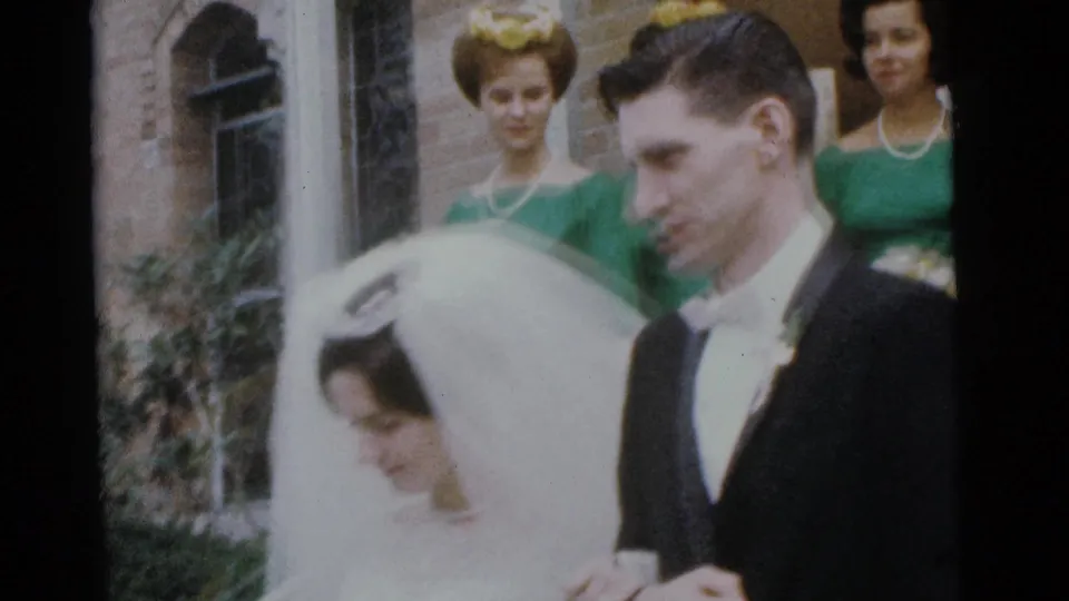 1961 Camden wedding party outside a brick church, with the veiled bride and tuxedoed groom in front of bridesmaids in green dresses.