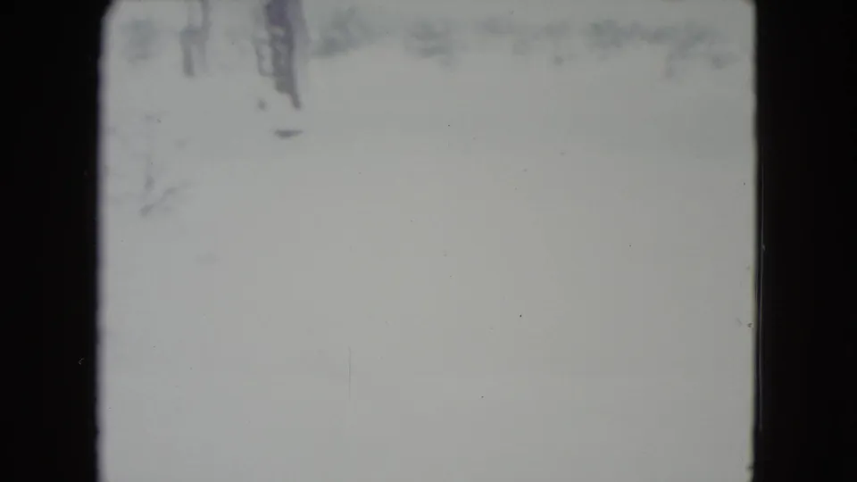 1960 Madison, Wisconsin winter frame with a pale snow field, faint horizon detail, and visible 8mm gate edge.