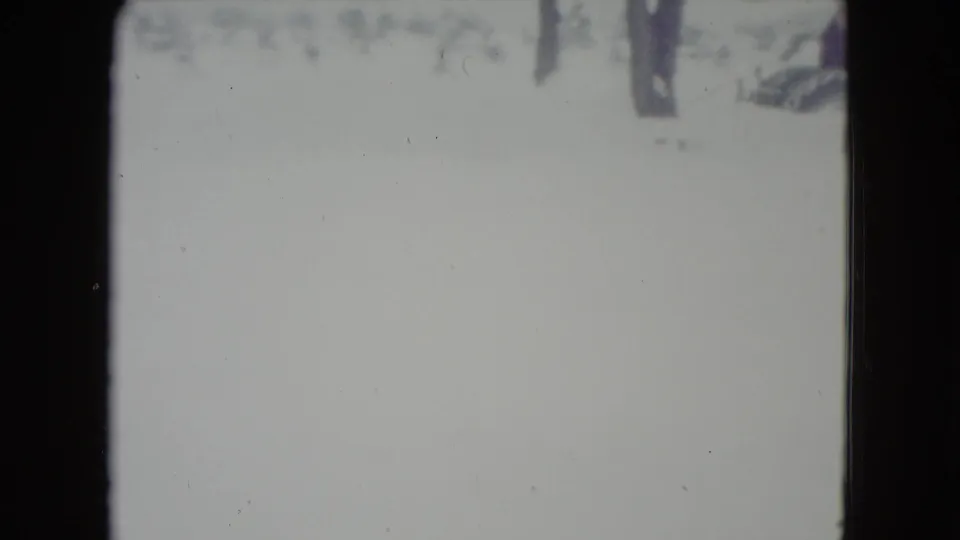 1960 Madison, Wisconsin 8mm frame showing a pale snow-covered field with bare trees and soft film exposure.
