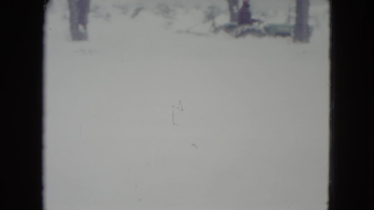 1960 Madison, Wisconsin home-movie frame of a bright snowy landscape with bare trees and visible 8mm frame edges.