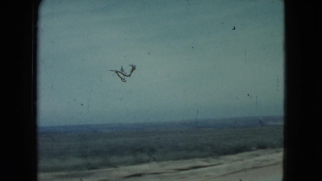 1960 Nevada driving view across sparse countryside, with a low horizon and road edge visible under a pale sky.