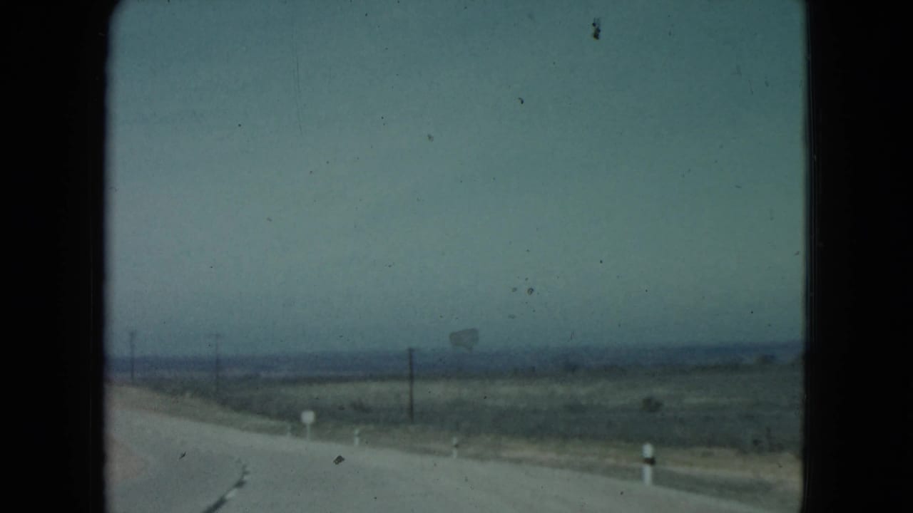 Open road and desert horizon with utility poles along the roadside.