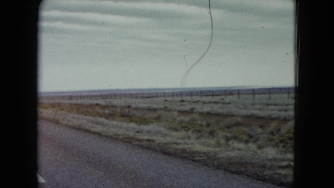 Empty road and scrub plain stretching toward a low horizon.