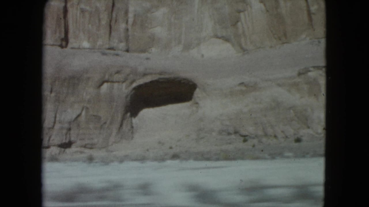 A pale desert rock wall and roadside edge appear in soft 8mm footage from a Nevada road trip.