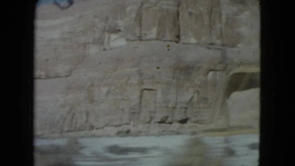 Faded 1960 Nevada road-trip frame with a rocky wall and blurred road surface at the bottom.