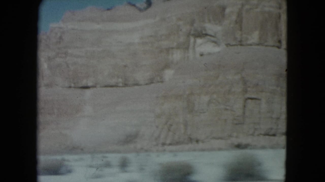 Sandstone cliff and desert foreground seen through dark 8mm frame borders.
