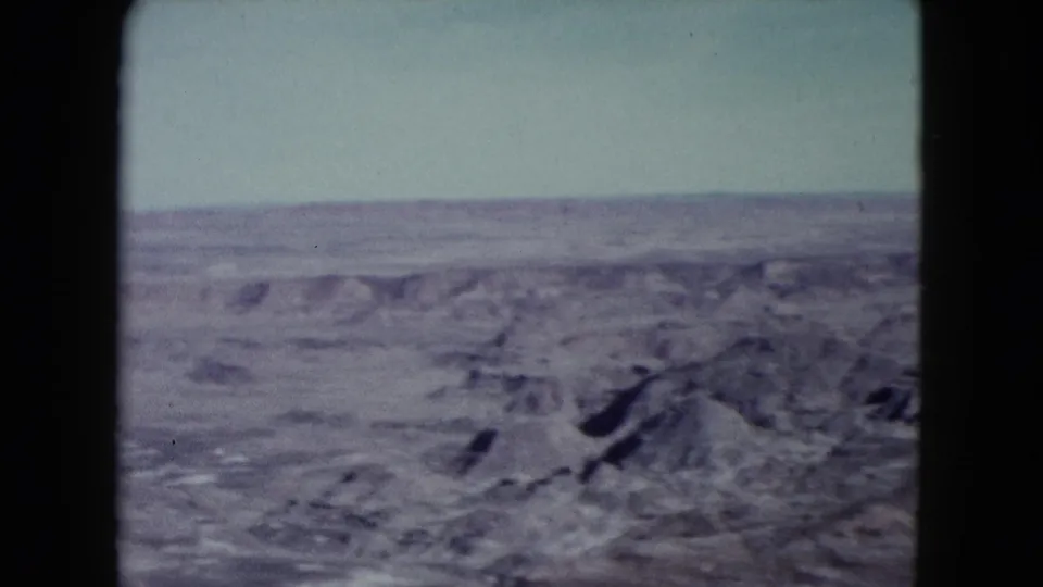 1960 Nevada desert view with eroded hills, broad arid ground, and a clear horizon.