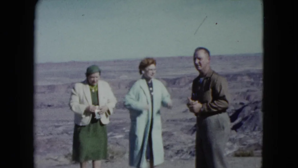 At the Nevada desert overlook, the three adults relax after the playful pose, with broad rocky terrain in the background.