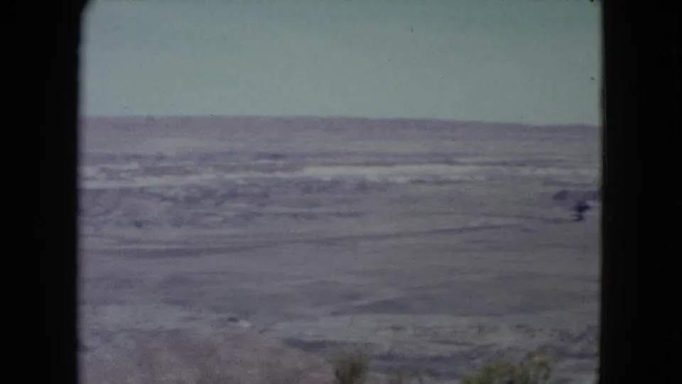 1960 Nevada 8mm view of a broad arid desert plain with a low distant horizon and dark film borders.