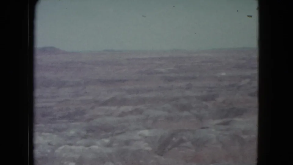 1960 Nevada 8mm frame showing a distant plateau across an arid, softly focused desert landscape.