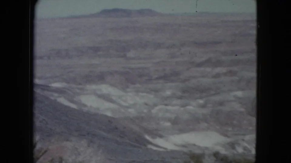 1960 Nevada 8mm view of dry washes and low ridges stretching toward distant desert hills.