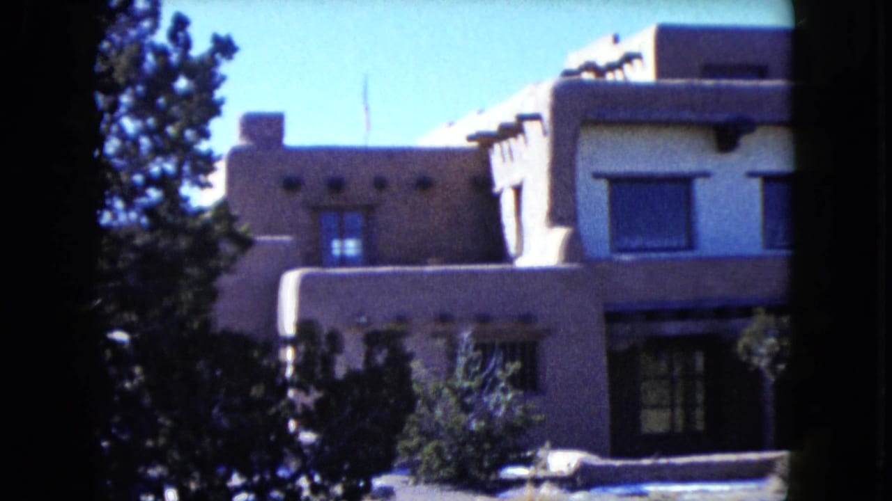 1960 Nevada frame of a Southwestern-style home exterior, partly obscured by trees and dark film-edge framing.