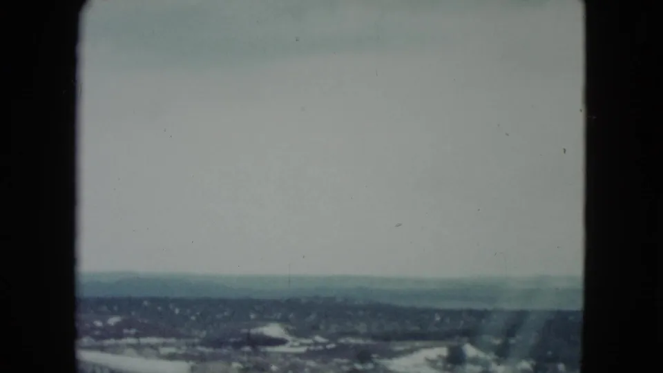 Wide 8mm view of hazy Nevada terrain and distant hills, framed by the moving-car perspective.