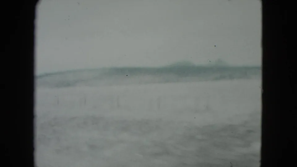 Soft, blurred 1960 Nevada 8mm view of open desert flats and a low ridge from a moving car.