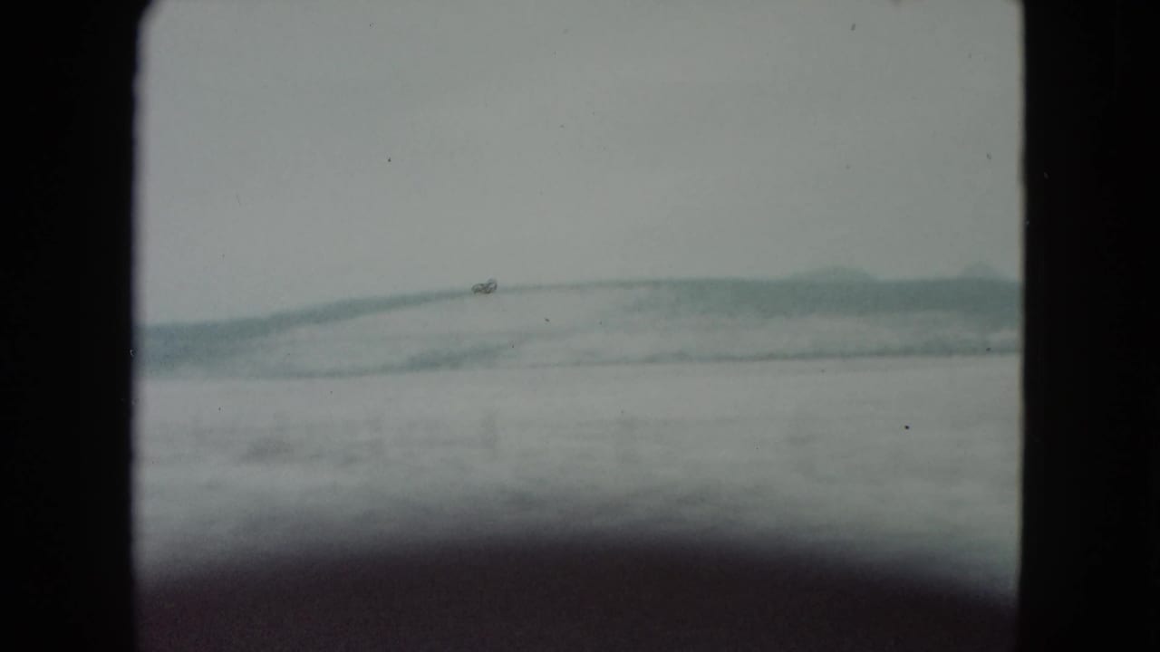 1960 Nevada road-trip view of pale snowy hills framed by the dark edges of the 8mm film gate.