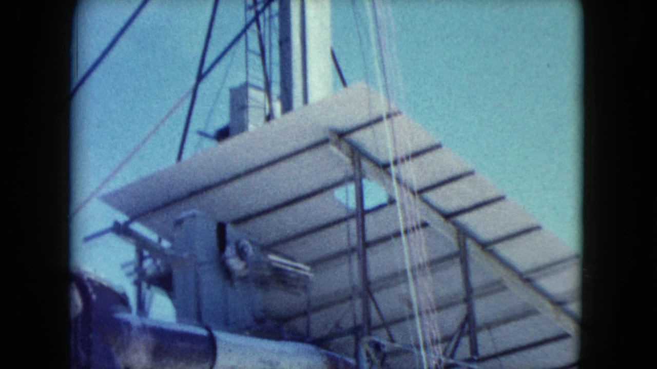 1960 Nevada industrial work-site frame with slatted roofing, tower structure, cables, and partial pipework against a pale sky.