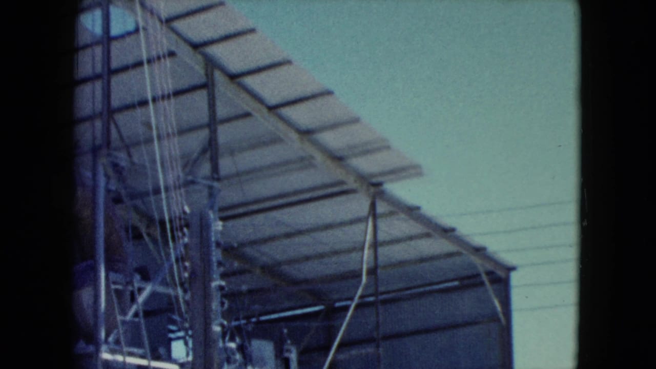 1960 Nevada industrial frame showing metal tower framing, hanging cables, pipework, and slatted roofing from a low angle.