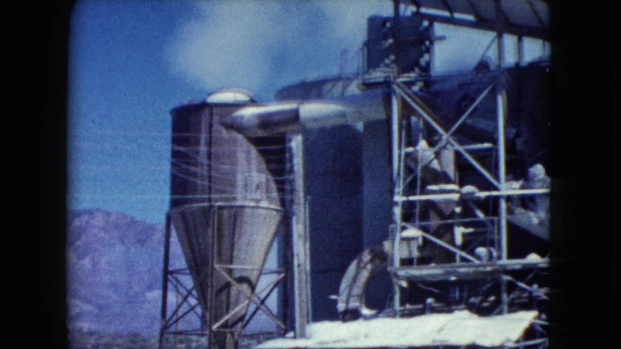 Silo, conveyor structure, and metal framework at an industrial site.