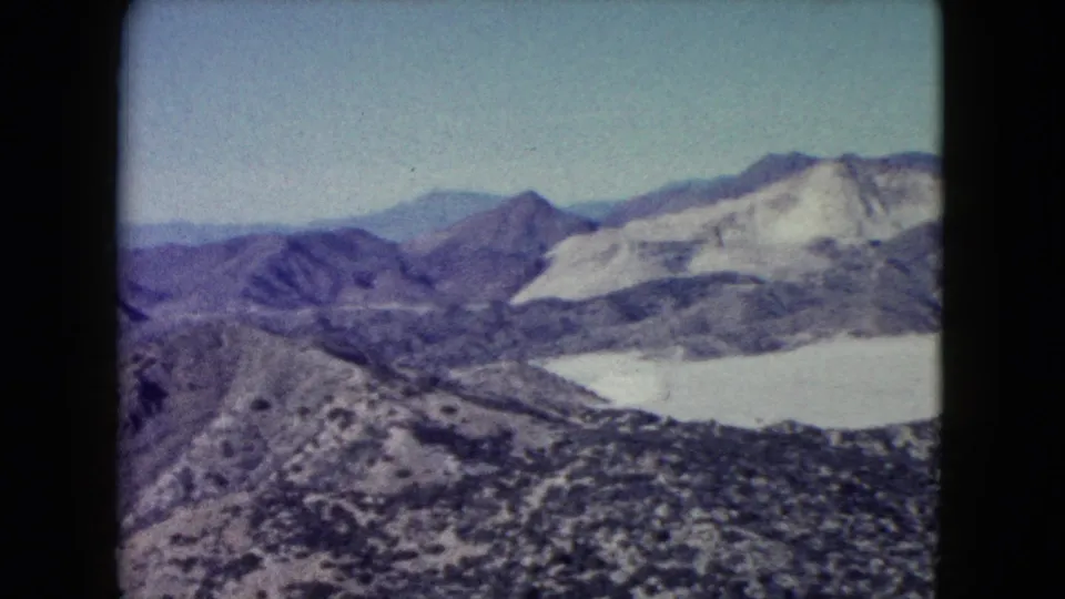 Nevada desert landscape in 8mm home-movie footage, showing broad mountain ridges and pale arid slopes.