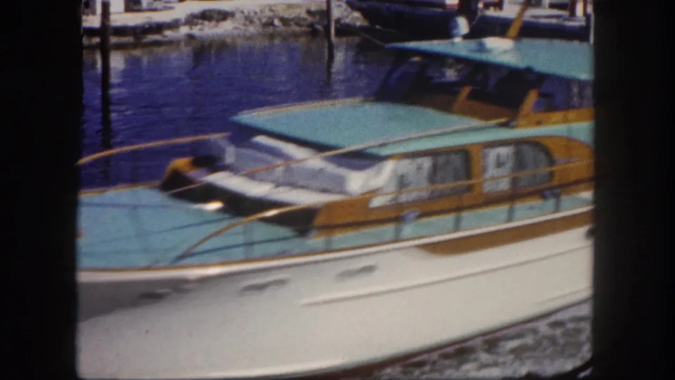 Vintage Tampa marina close-up of a moored motorboat with turquoise canopy, white hull, and wood trim.
