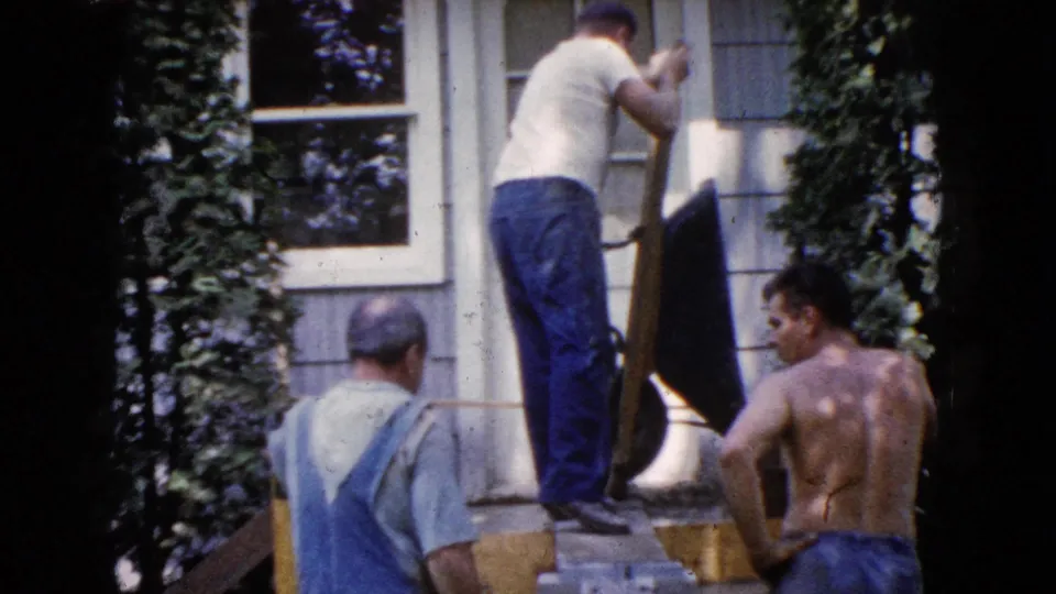 At the end of the clip, a man balances on the platform with a board while two others stand below in the 1960 Wauconda scene.