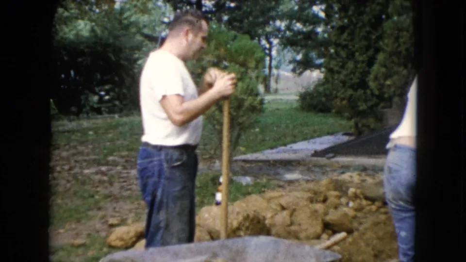 The final 1960 Wauconda frame shows a man holding a shovel near dug soil, a wheelbarrow, trees, and a partial figure at the edge.