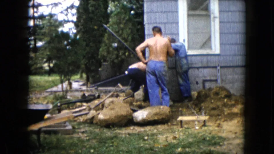 The final frame shows the backyard work area in Wauconda, Illinois, with adult men, rocks, tools, and house siding visible.