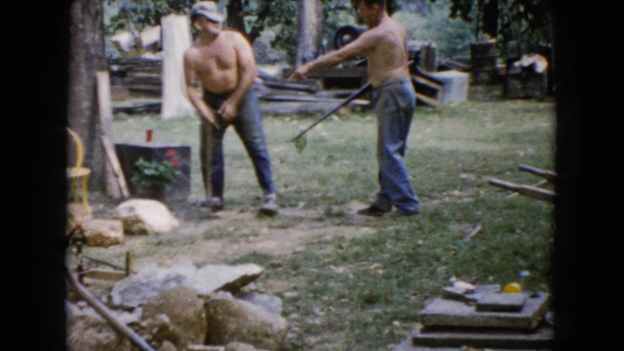 In the Wauconda yard scene, one man stands with a shovel as another extends a long-handled tool near rocks, trees, and scattered materials.