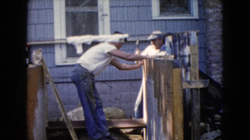 The men continue positioning and fastening wood in the 1960 Wauconda home-project scene.