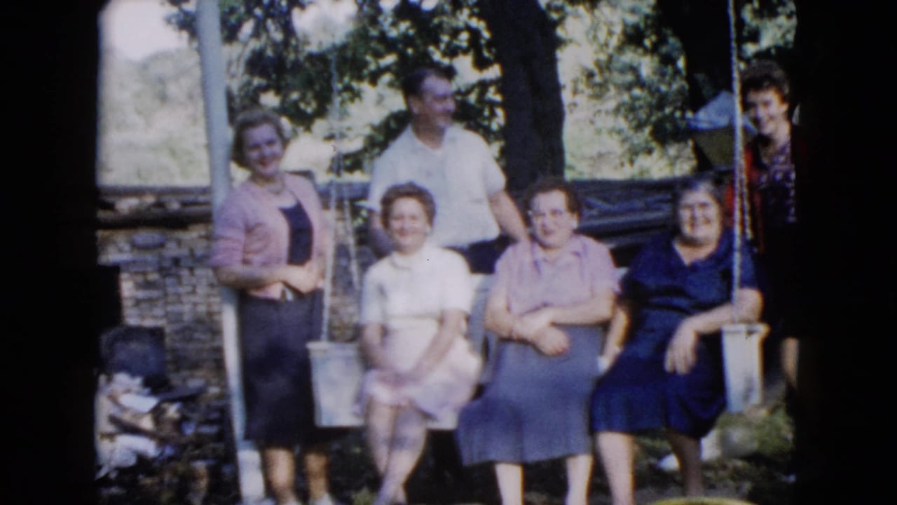 The Wauconda family group continues posing in the yard, with women seated on the swing and others standing behind or beside them.