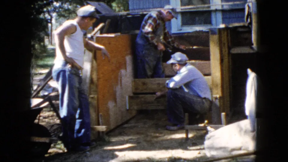 At the end of the short clip, three men continue outdoor deck work beside a house in the supplied 1960 Wauconda setting.