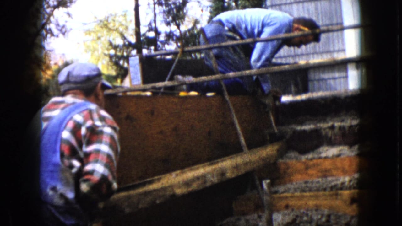 A 1960 Wauconda outdoor construction scene shows one man leaning over the form while another watches from beside it.