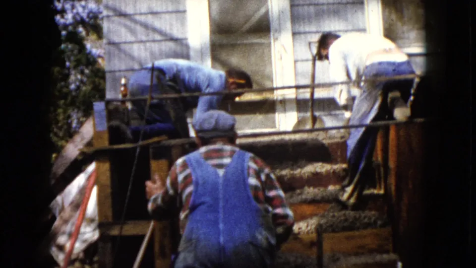 The residential construction crew works around wood forms and wet cement on exterior steps in Wauconda, Illinois.