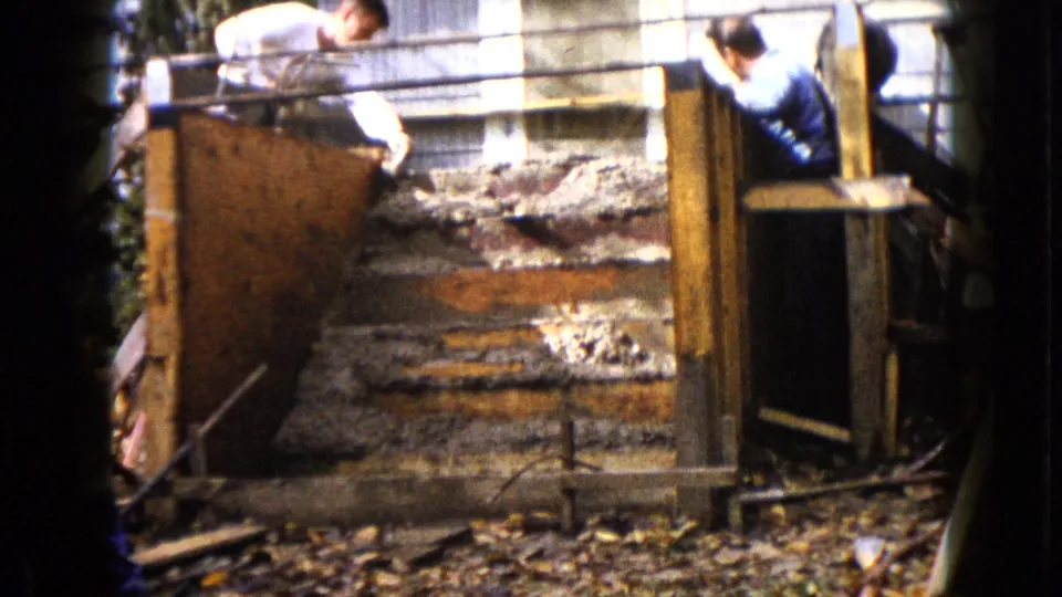 The final frame shows one man reaching over the form and another beside the concrete steps in the 1960 Wauconda home construction scene.