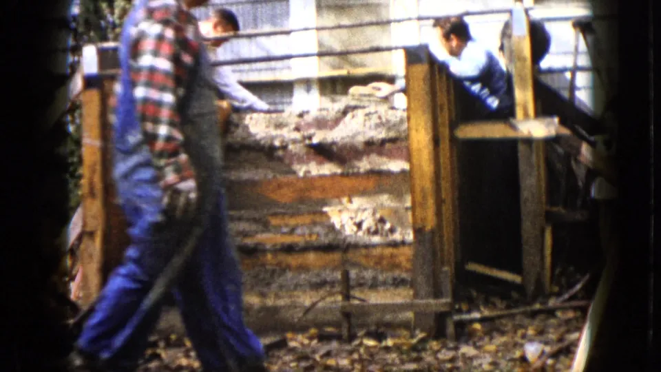 In Wauconda, Illinois, 1960 home-movie footage, men work around wooden forms for concrete steps beside house siding.