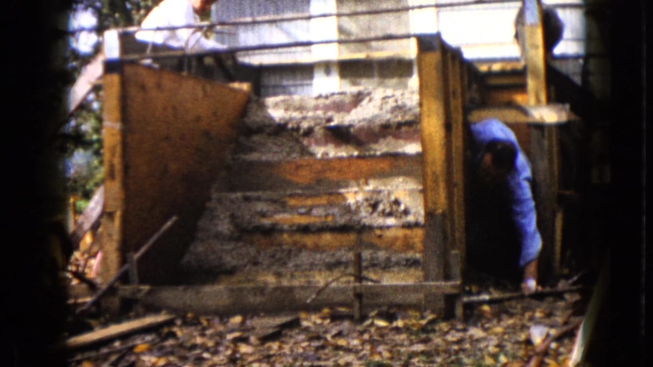 In Wauconda, Illinois, 1960 home-movie footage, one man leans over the top of a wooden form while another works inside the frame.