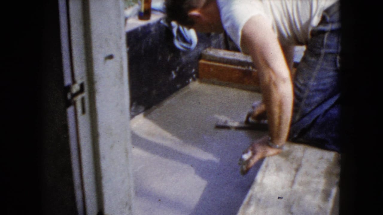A 1960 Wauconda frame shows the man using a hand tool on wet pavement while leaning over a wooden form.