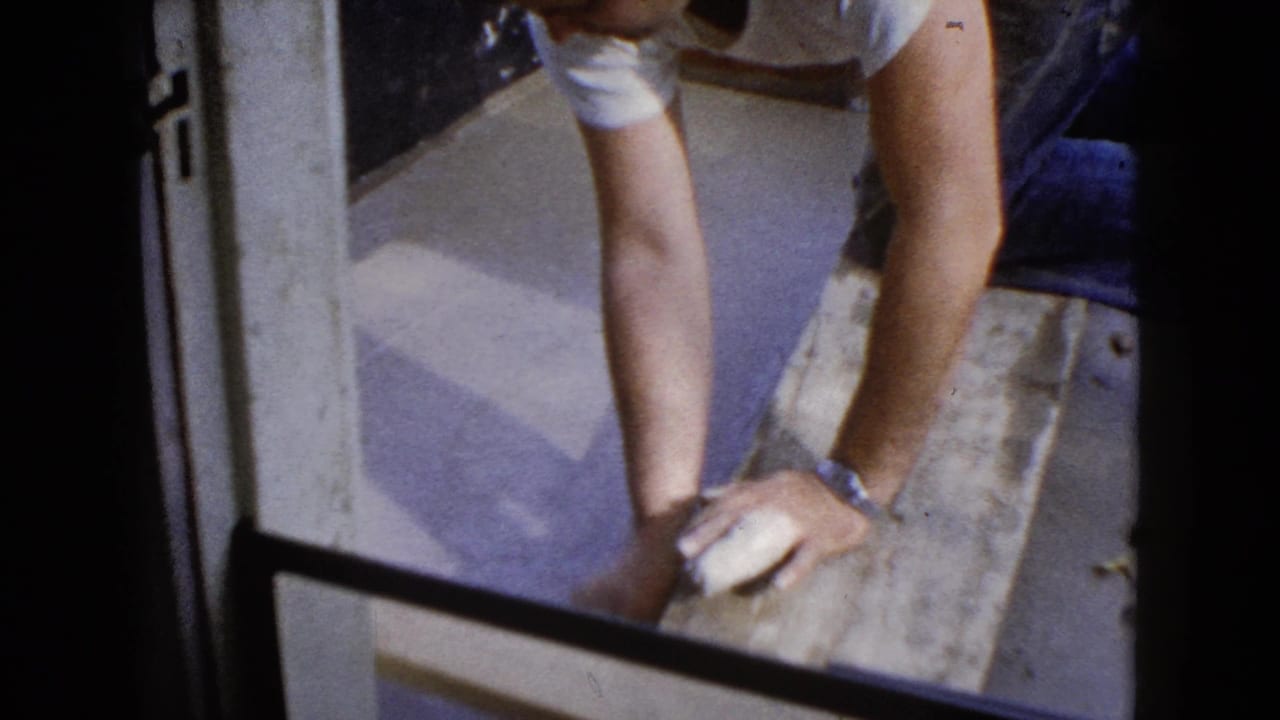 The final frame shows the man's arms and work clothes close to the doorway as he braces over the wet pavement area.