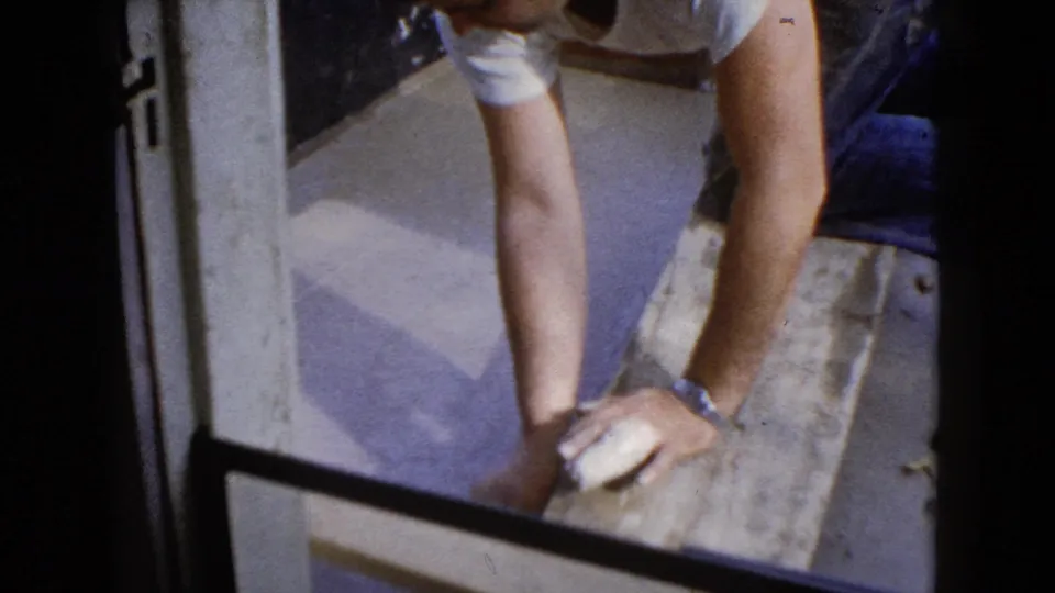 The final frame shows the man's arms and work clothes close to the doorway as he braces over the wet pavement area.