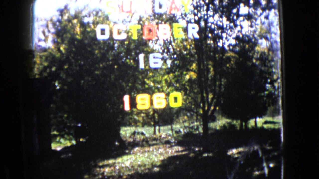 Color date lettering appears over trees, grass, and a bright outdoor background.
