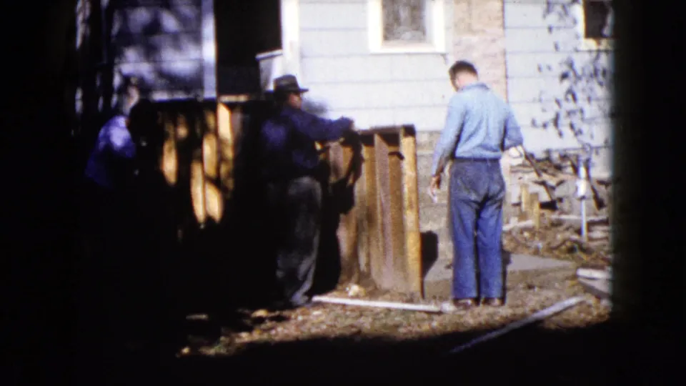 In Wauconda, Illinois, two men are visible near a wooden outdoor structure and light-sided house at the end of the clip.