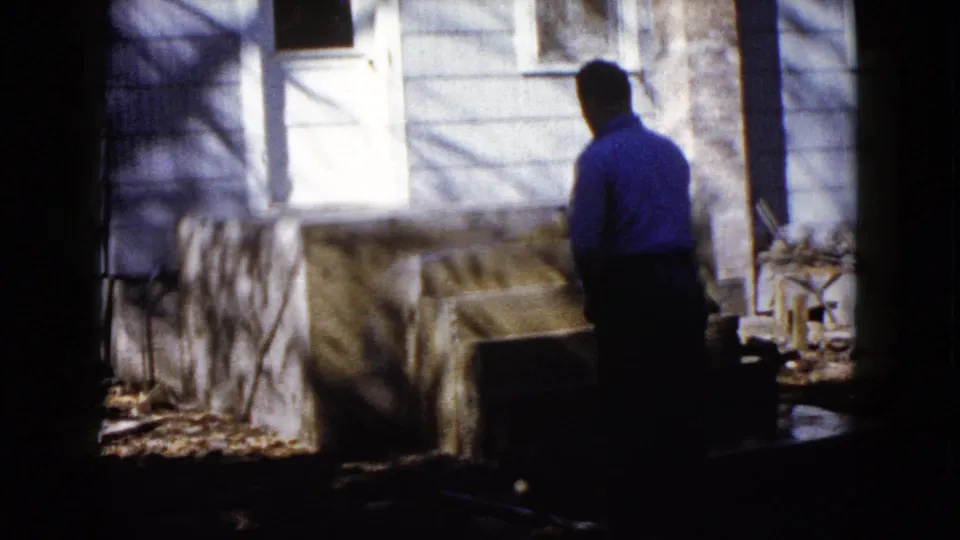 At the end of the clip, the man stands near the newly worked concrete area beside the Wauconda house exterior.