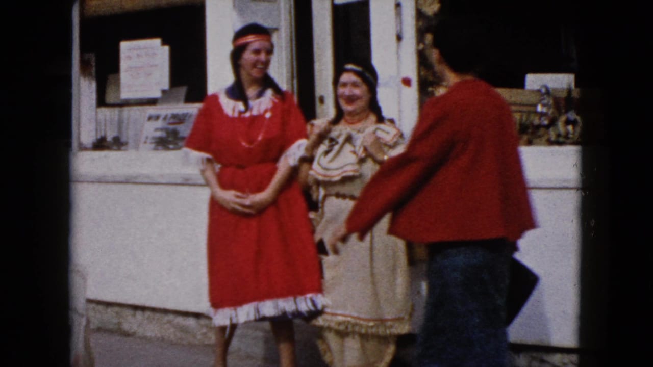 In Wauconda, Illinois in 1960, two costumed women stand outside a storefront as a third woman in red faces them.