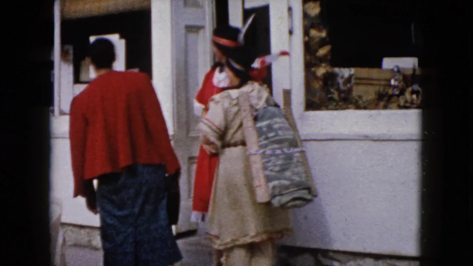 Outside the Wauconda storefront, the costumed women turn toward the window as the woman in a red sweater stands with her back to camera.