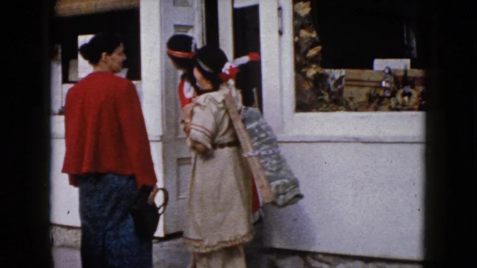 The final 1960 Wauconda frame shows the women clustered by the shop window, including a beige-costumed woman with a patterned bag.